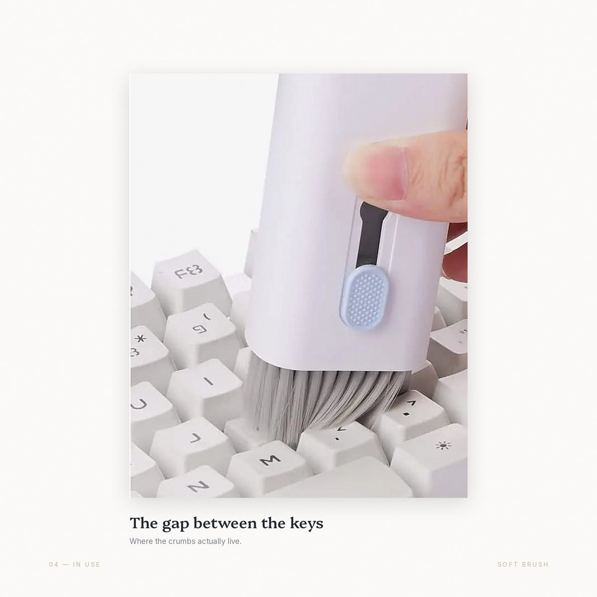 The retractable soft brush sweeping debris out of the gaps between keyboard keys